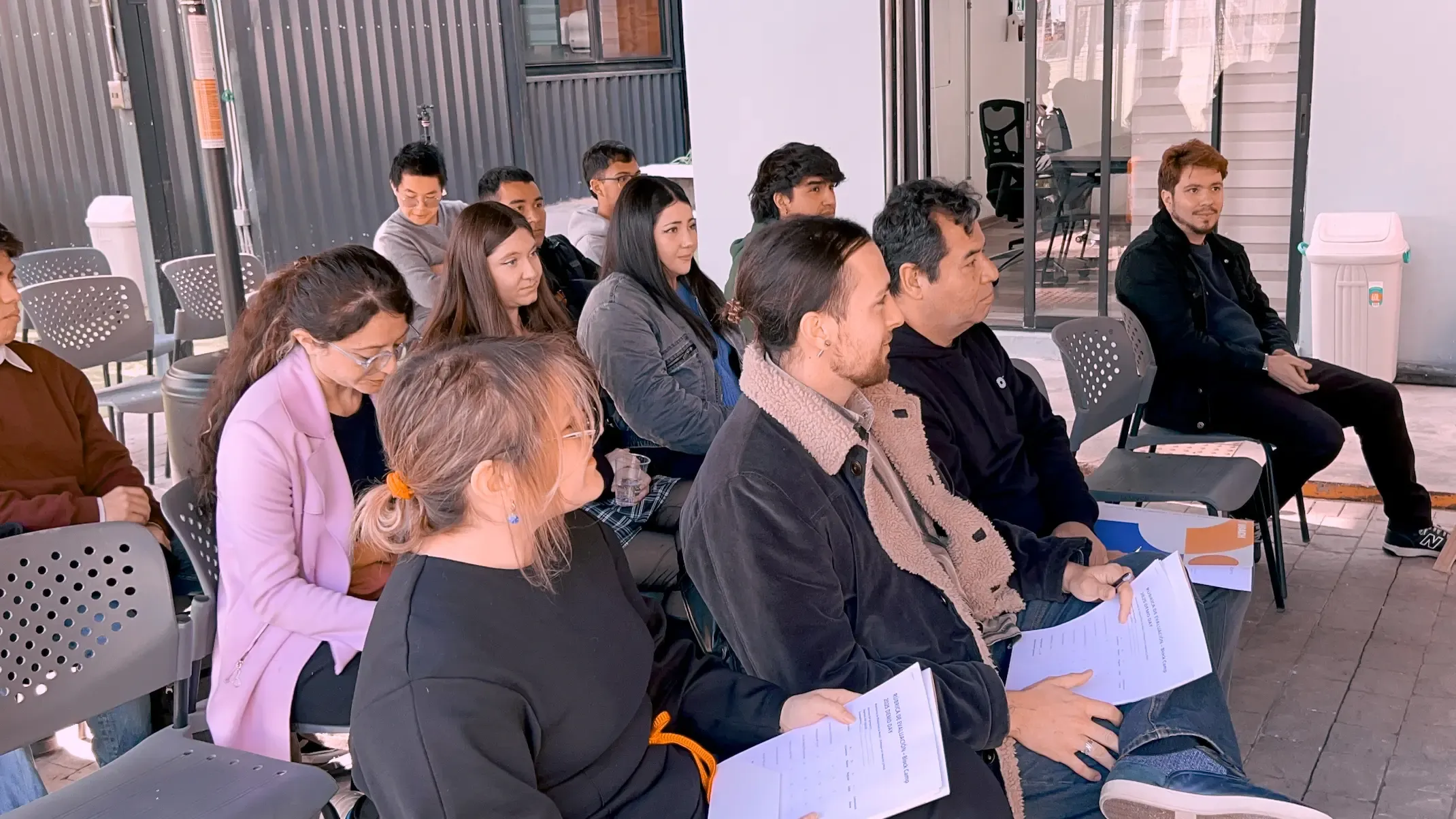 Participantes de un taller de Blockchain sosteniendo materiales impresos.