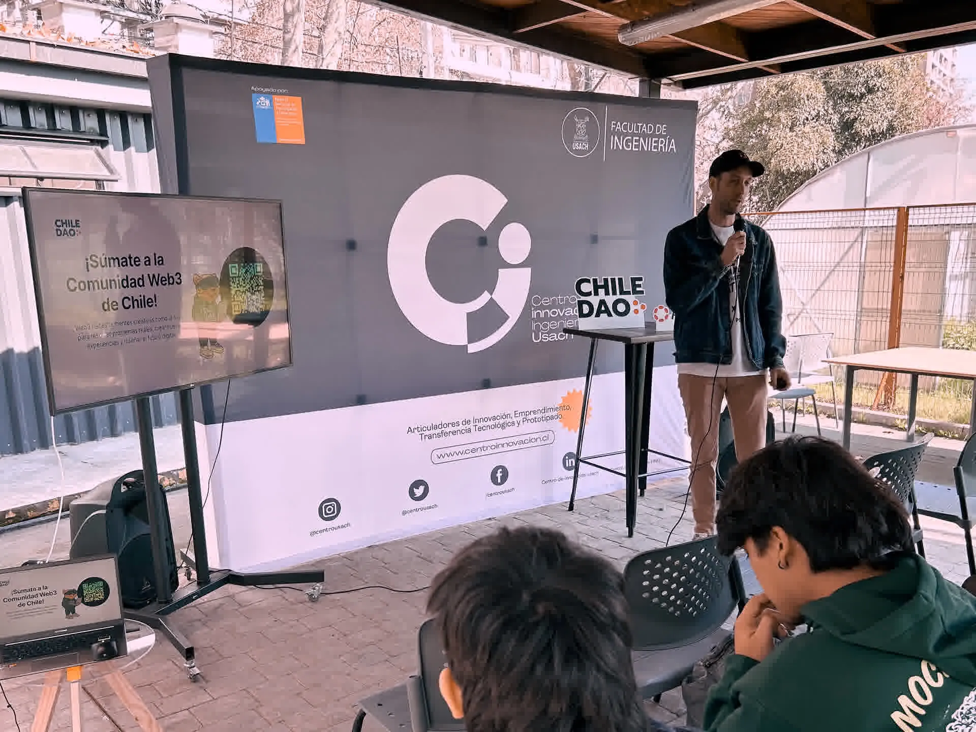 Expositor con micrófono junto a una pantalla sobre la comunidad Web3 de Chile.