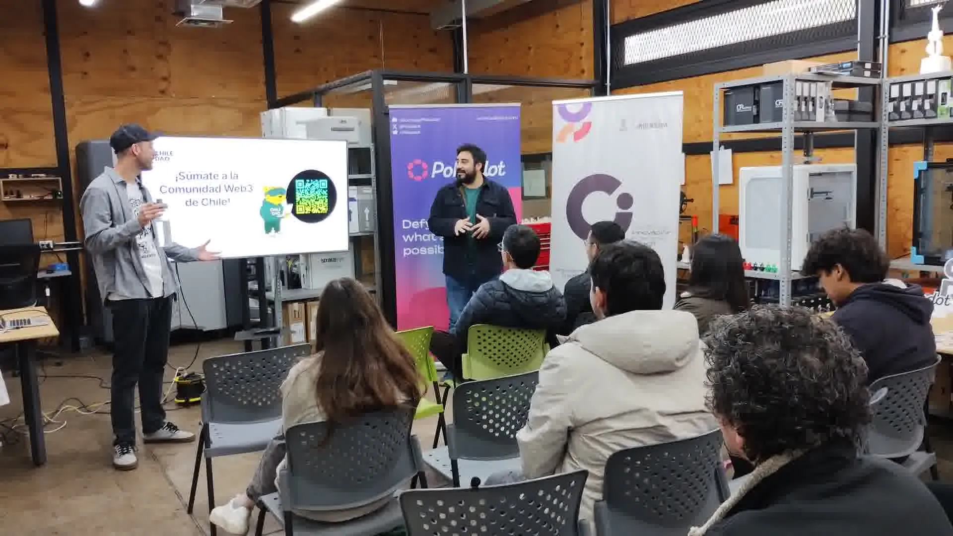 Dos expositores conversando frente a participantes en un taller.